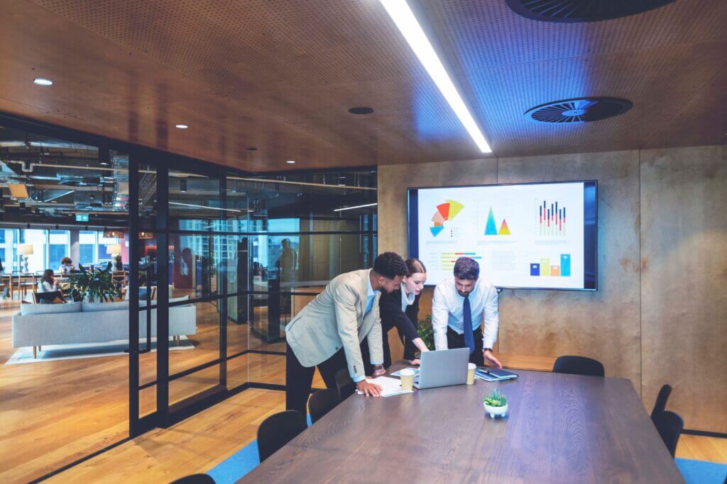 technology data on boardroom screen plus people in meeting